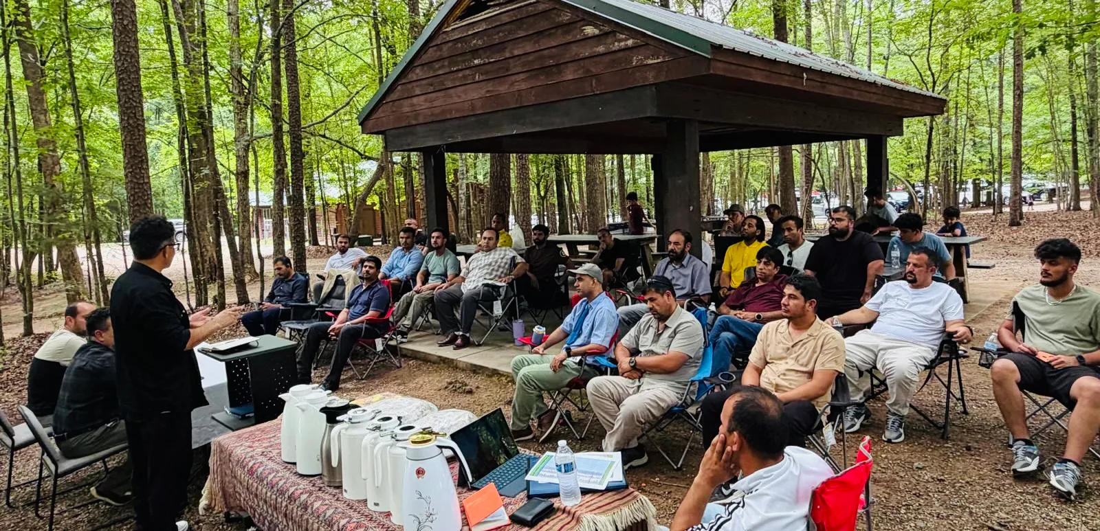 An audience seated together at an outdoor Maihan Association gathering.