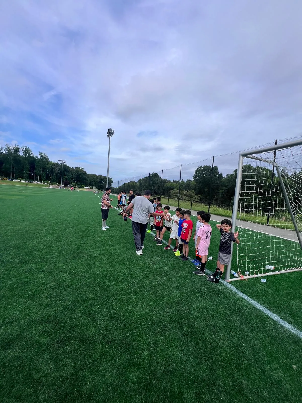 A coach working with young players during a Maihan Association soccer practice.